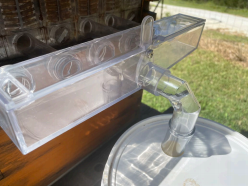 Manifold outlet tube feeding into a bucket